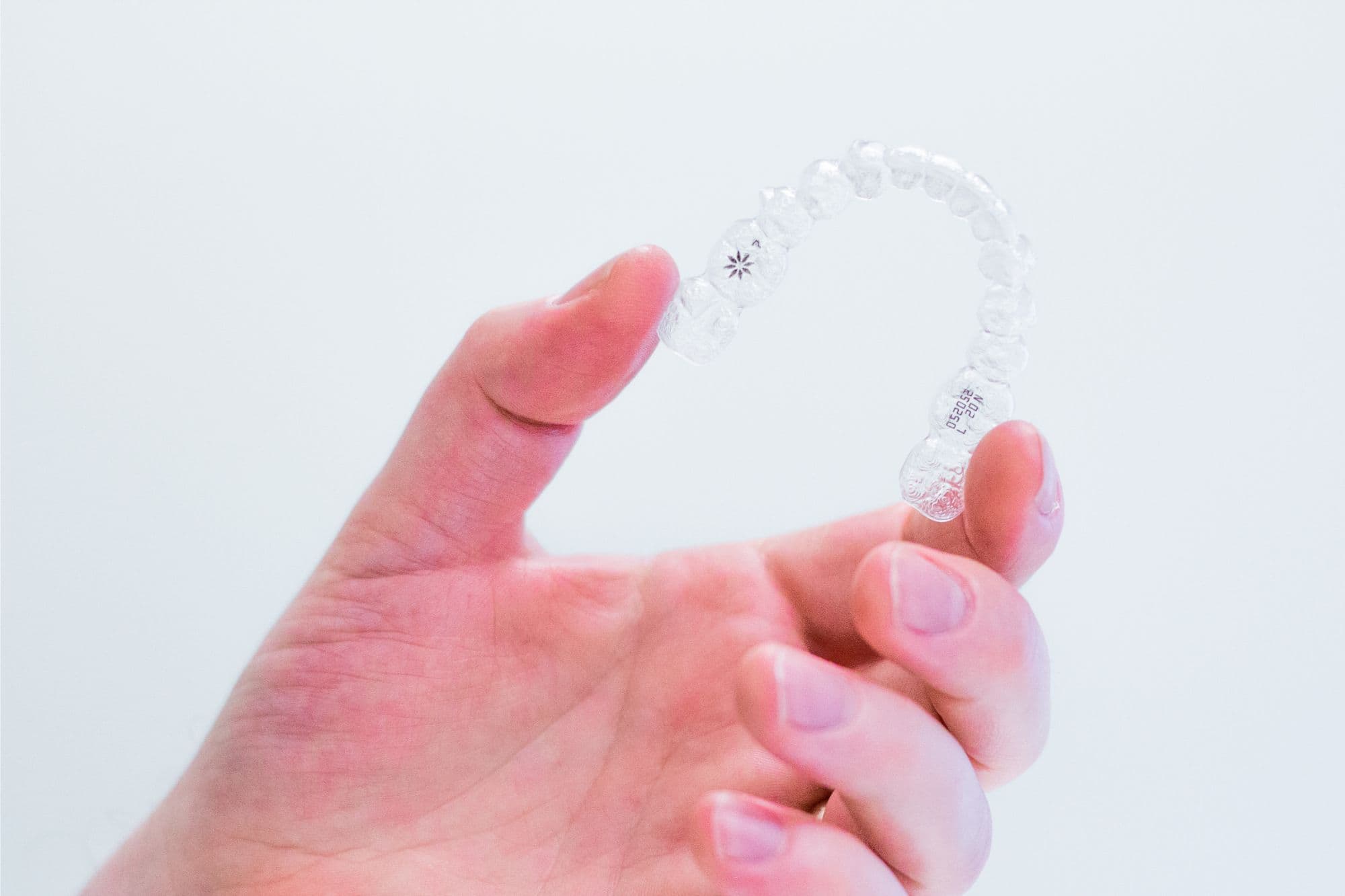 hand-holding-invisalign-aligners